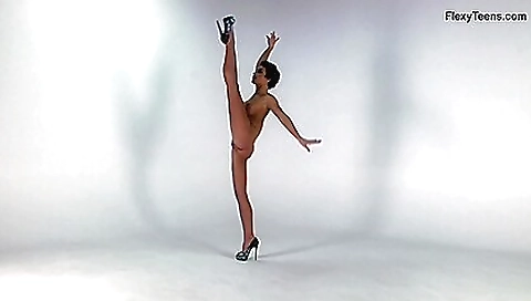 Amazing brunette girl poses on a gym and stretches her body