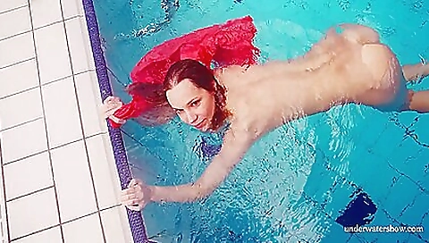 Cute brunette teen wearing a pink dress in the pool